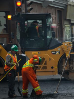 Workers and machinery paving a road in urban Qu&eacute;bec City, Canada.