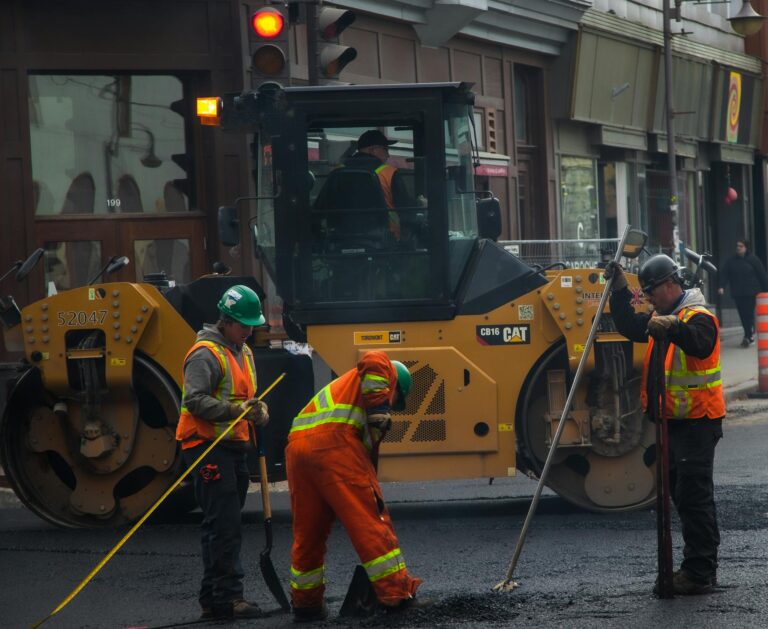Workers and machinery paving a road in urban Qu&eacute;bec City, Canada.